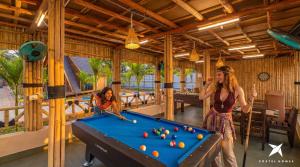 a woman and a girl playing pool in a room at Zostel Homes Hampi in Hampi