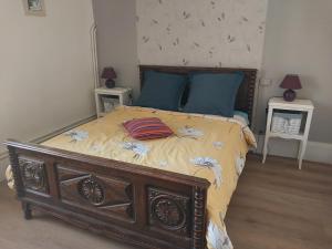 a bedroom with a large wooden bed with blue pillows at Jolie maison de Potier in Accolay