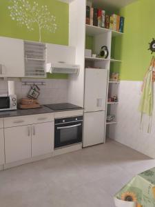 a kitchen with white cabinets and a black oven at Jolie maison de Potier in Accolay