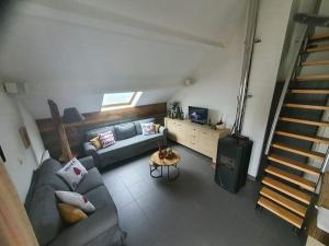 a living room with a couch and a staircase at Escape at Durbuy in Durbuy