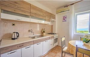 a kitchen with white cabinets and a table and a window at Sea & Mountain View Apartments - Metajna in Metajna