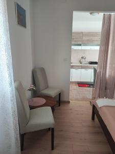 a living room with two chairs and a table at Sea & Mountain View Apartments - Metajna in Metajna
