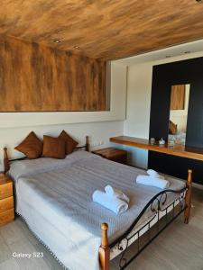 a bedroom with a bed with towels on it at Moumis Luxury Apartment in Limenaria