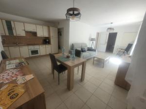 a kitchen and living room with a table and a couch at Meublé Symphonie in Niederbronn-les-Bains