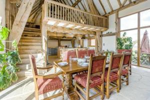 a dining room with a wooden table and chairs at Unique Luxury Barn in Tenbury