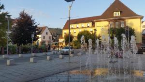 a fountain in the middle of a street with a building at Meublé Symphonie in Niederbronn-les-Bains