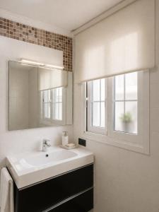 a white bathroom with a sink and a mirror at Abril Plaza de España Boutique in Nerja +13 photos