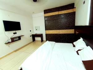 a bedroom with a bed and a flat screen tv at Hotel Vivara in Lucknow
