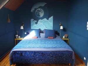 a blue bedroom with a bed with a blue wall at La Sorcière et le Korrigan in Paimpont