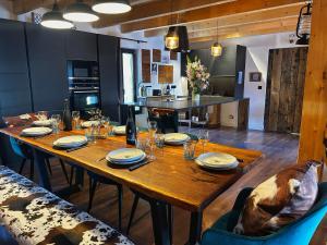 a wooden table with plates and wine glasses on it at Le chalet des fontaines in Allos