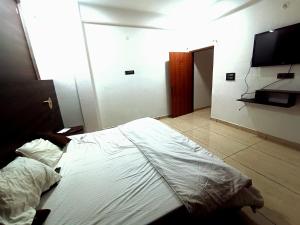 a bedroom with a bed and a flat screen tv at Hotel Vivara in Lucknow