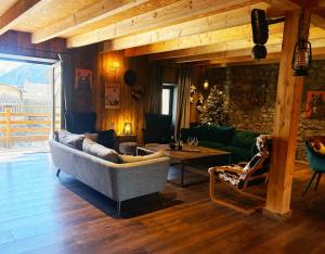 a living room with a couch and a table at Le chalet des fontaines in Allos