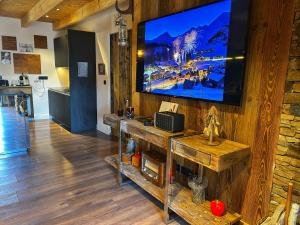 a living room with a large flat screen tv on a wall at Le chalet des fontaines in Allos