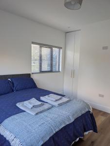a bedroom with a blue bed with towels on it at The Unplugged Snug in Kilkenny