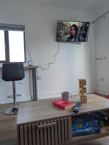 a room with a table with a tv on the wall at The Unplugged Snug in Kilkenny