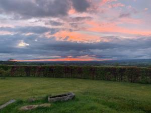 a field with a sunset in the background at The Unplugged Snug in Kilkenny