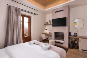 a bedroom with a white bed and a fireplace at Μikri Arktos Boutique Hotel in Dimitsana