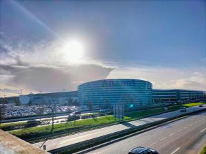 a large building in front of a busy freeway at Appartement moderne avec parking privé Lit connecté LED & rétroprojecteur 5 min Zénith in Saint-Herblain