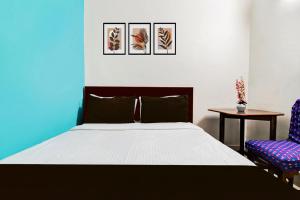 a bedroom with a bed and two chairs at Hotel O Akash Namostay in Jamshedpur