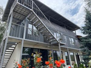a house with a balcony and orange flowers at Infinity Hotel in Cholpon-Ata