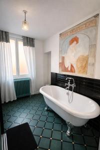 a bathroom with a tub and a painting on the wall at B&B Villa Marie-Lou in Le Portel +16 photos