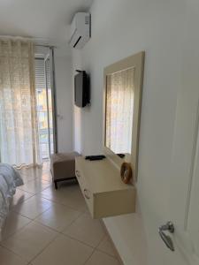 a bathroom with a mirror and a dresser and a television at Apartment Gerti - Sea view in Shëngjin