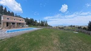 a villa with a swimming pool and a house at Private Villa Maothis in Corfu