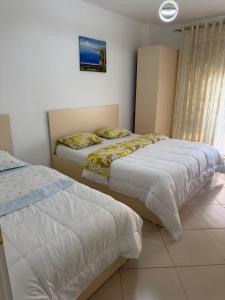 a bedroom with two beds and a window at Apartment Gerti - Sea view in Shëngjin