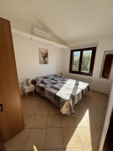 a bedroom with a bed with a blanket on it at Casetta Alamar in San Teodoro
