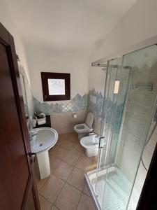 a bathroom with a shower and a toilet and a sink at Casetta Alamar in San Teodoro +9 photos