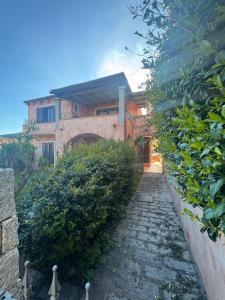 a stone path leading to a house with a building at Casetta Alamar in San Teodoro