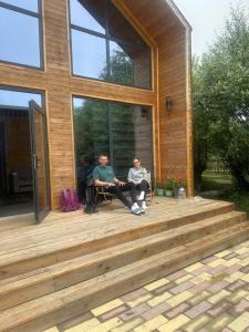 two men sitting on a porch of a house at Zhyrgallaif in Darkan