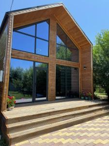 a house with a large window and a wooden deck at Zhyrgallaif in Darkan