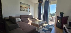 a living room with a brown couch and a table at Boka Bay in Tivat