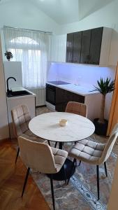a kitchen with a table and chairs in a kitchen at Vila Sentić in Vranje