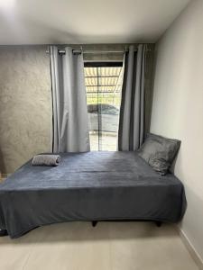 a large bed in a room with a window at Chalé Dona Ceci in Cavalcante