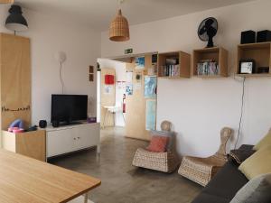 a living room with a couch and a tv at Hostel do Mar in Carrapateira