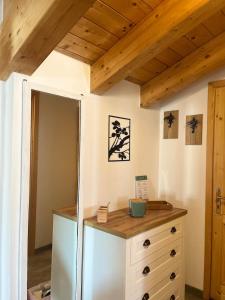 a bedroom with a dresser and a wooden ceiling at Mansarda Mitta Coel in Torre di Santa Maria