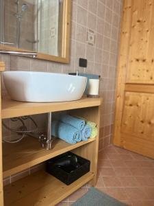 a bathroom with a sink and towels on a shelf at Mansarda Mitta Coel in Torre di Santa Maria +36 photos