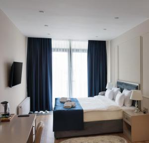 a bedroom with a bed and a large window at Podium Boutique Hotel in Yerevan