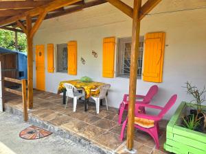 a patio with a table and chairs on a house at L'Orange Volcanique in Saint-Pierre