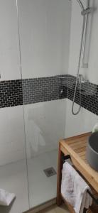 a bathroom with a glass shower with a sink at Maison à la mer in Vendres