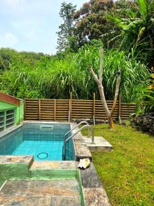 a swimming pool in a yard next to a fence at L'Orange Volcanique in Saint-Pierre