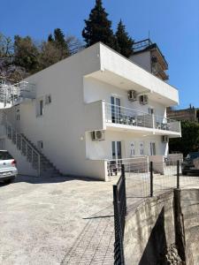a white building with stairs and a fence at Apartments Sole 2 in Sutomore