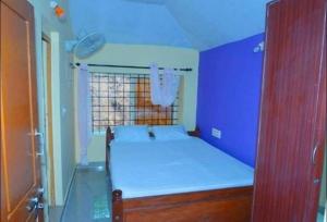 a small room with a bed and a window at Gope town mudigere in Mudigere