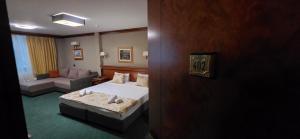 a hotel room with a bed and a couch at HOTEL ELSA in Skopje