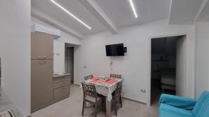 a dining room with a table and a tv on the wall at Cilento My Home in Albanella