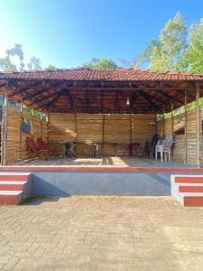 a large wooden pavilion with chairs and tables at Gope town mudigere in Mudigere