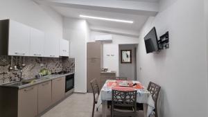 a kitchen with a table and chairs and a kitchen with white cabinets at Cilento My Home in Albanella