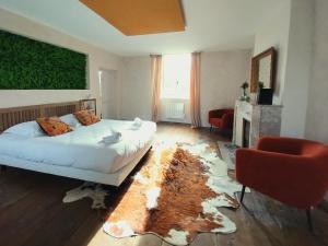 a bedroom with a large bed and a rug at Maison Tyto Alba in Saint-Victurnien